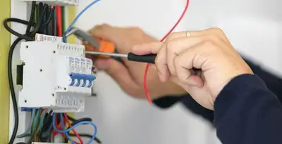 Electrician installing and adjusting circuit breakers in an electrical panel in Fort Wayne, IN