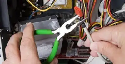 Licensed electrical contractor performing electrical repair with tools in New Haven, IN