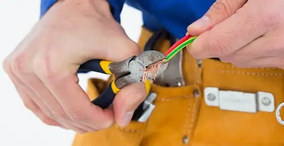 licensed electrician securing electrical wiring with professional tools during service work in Fort Wayne, IN