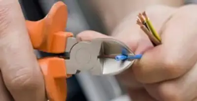 licensed electrician performing precise wire cutting and preparation during electrical service in Fort Wayne, IN