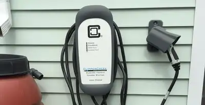 Outdoor electric vehicle charger installation on residential wall in Fort Wayne, IN