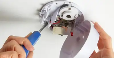 Certified technician wiring smoke detector during installation in Fort Wayne, IN